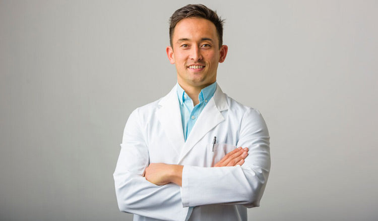 Clinician in a white lab coat with arms folded