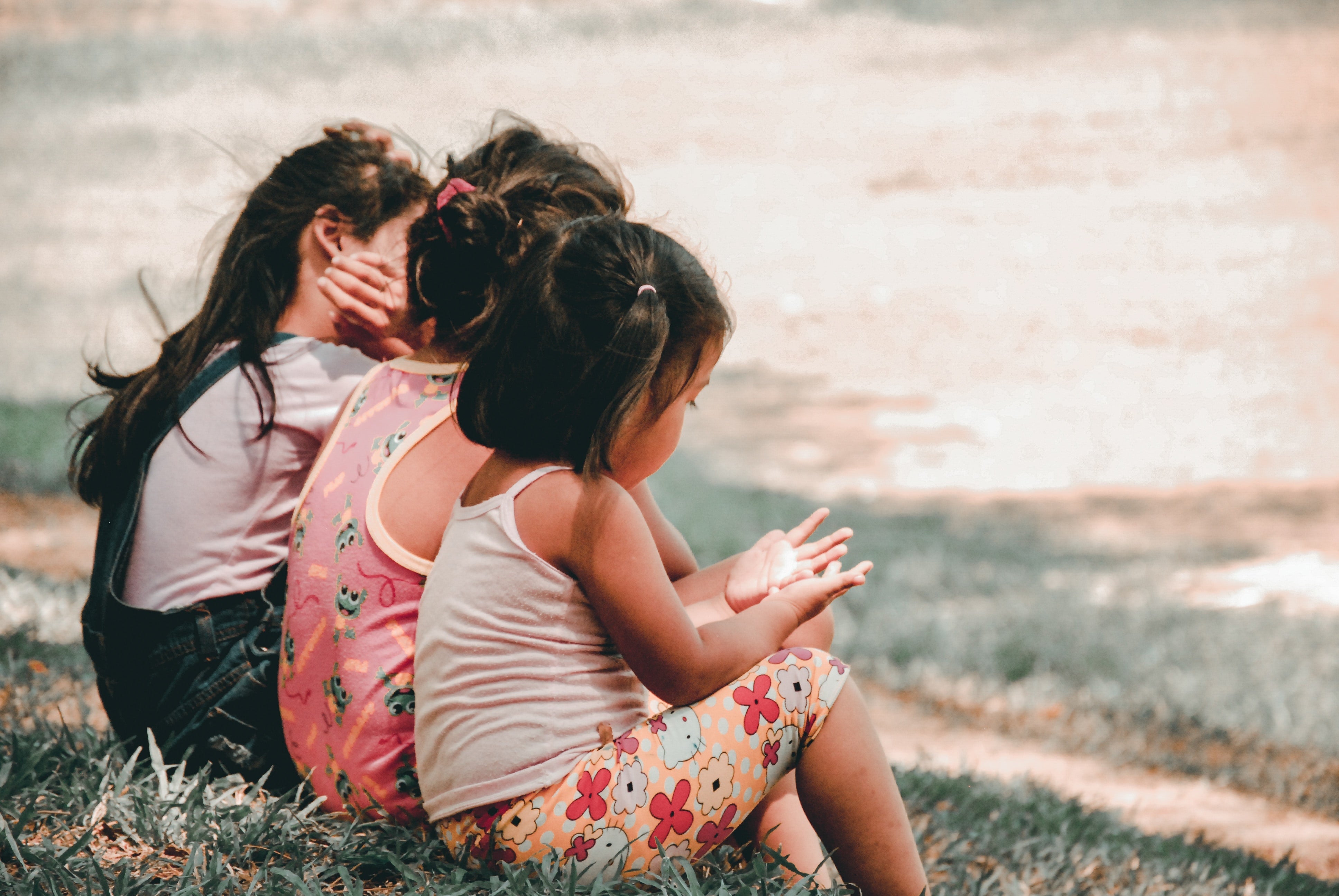 Two young girls sitting together on the grass