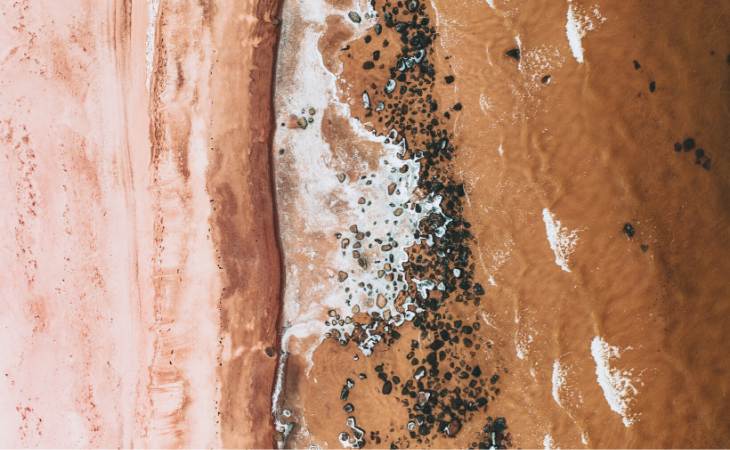 Aerial view of red desert meeting pink sand